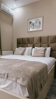 Quarto com uma cama grande, cabeceira, radiador e ar condicionado.