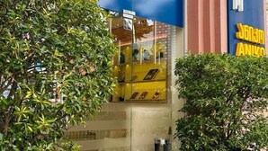 L’entrée d’un hôtel avec une façade bleue et une enseigne jaune.