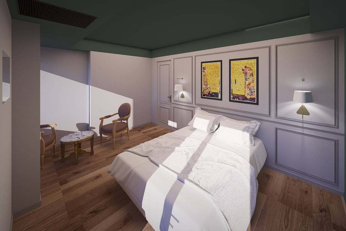 Un dormitorio con una cama grande, una silla, una mesita y dos lámparas de pared.