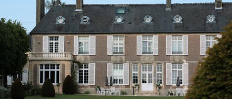 A large, historic building with multiple windows and a symmetrical facade.
