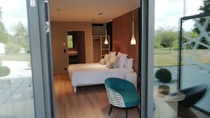 Un dormitorio moderno con cama, una silla y un escritorio.