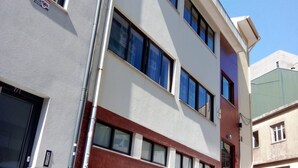 A multi-story building with a flat facade, large windows, and a red brick section. - Apartamento Doria - Center Porto Economic Huge Fla (Porto)