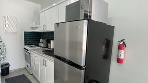 A modern kitchen with stainless steel appliances, white cabinets, and a tiled backsplash. - Sea Breeze Tunnel Hideaway 6 (Terranova)