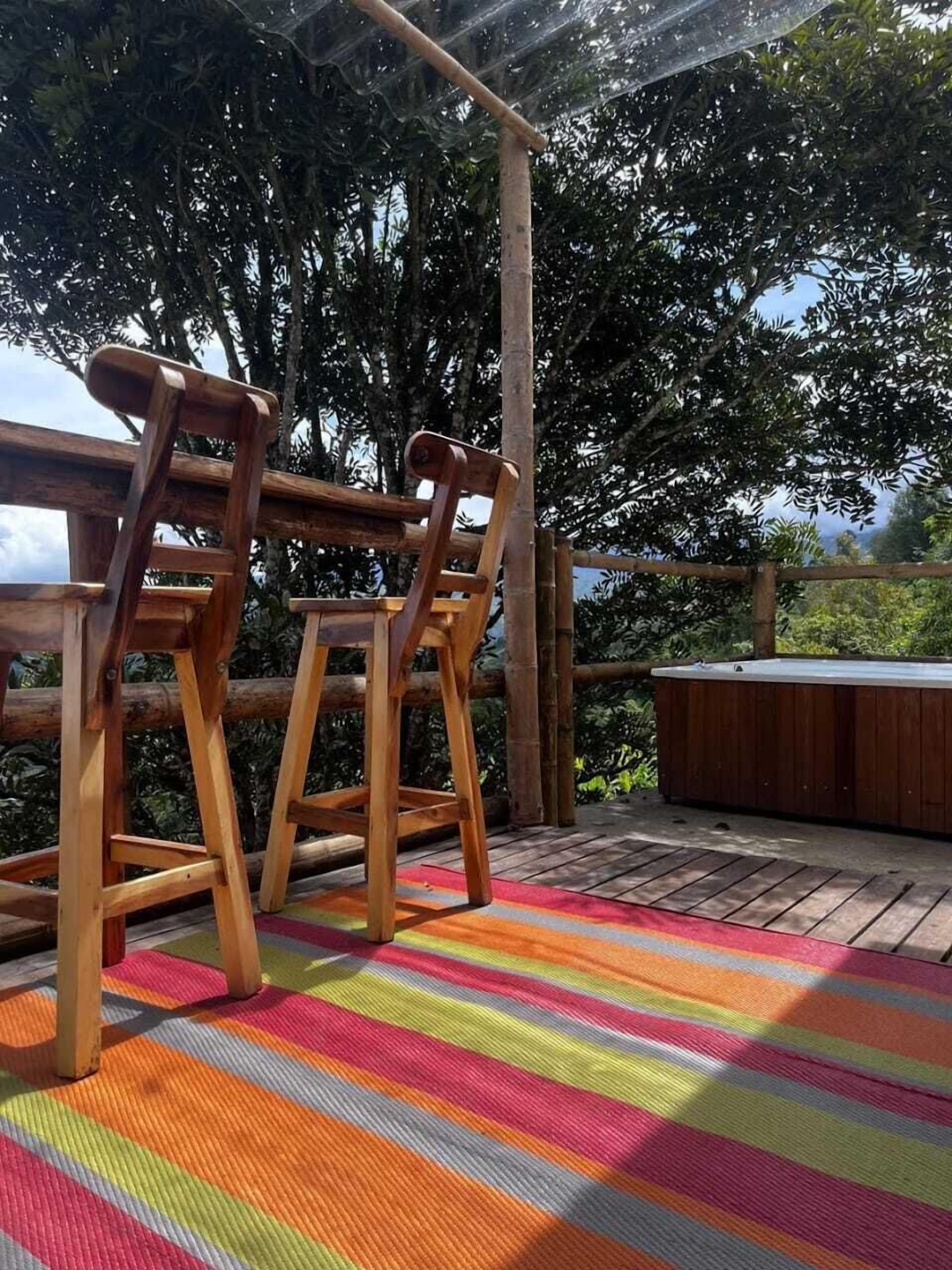 Eine Holzterrasse mit zwei Stühlen und einem Whirlpool.