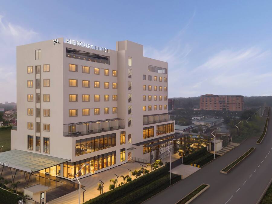 A modern hotel with multiple floors, large windows, and a covered outdoor area.