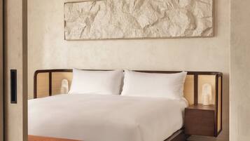 A modern bedroom with a large bed, a nightstand, and a bench.