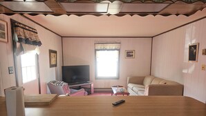 A living room with a TV, sofa, and a wooden table. - Charming 3-bedroom, 2 bath-room house with WiFi and AC in Lewes. (Lewes)