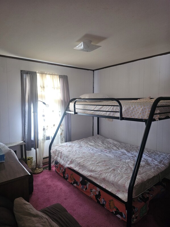 A bunk bed room with a desk and a window with curtains. - Charming 3-bedroom, 2 bath-room house with WiFi and AC in Lewes. (Lewes)