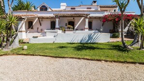 A traditional building with a tiled roof, a covered patio, and a well-maintained lawn. - FLH Belaventura Villa (Boliqueime)