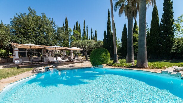 A swimming pool with lounge chairs and umbrellas, surrounded by trees and a well-maintained lawn. - FLH Belaventura Villa (Boliqueime)
