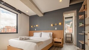 A modern bedroom with a large bed, bedside tables, a wardrobe, and a city view. - Chic 1 BR in Chapinero (Bogotá)