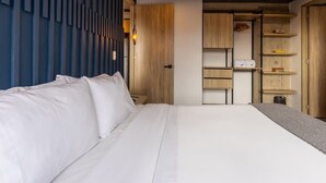 Ein modernes Schlafzimmer mit einem großen Bett, integrierten Regalen und einem Holzschrank.