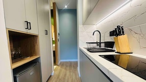 A modern kitchen with a black sink, wooden countertop, and a knife block. - Amazing Apartment in Parque 93 (Bogotá)