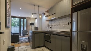 A modern kitchen with stainless steel appliances, a built-in oven, and a large island. - Amazing 1 Br in Candelaria (Bogotá)