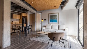 A modern interior with a wooden ceiling, a white sofa, and a dining area with chairs and a table. - Stunning 1 BR in Chapinero (Bogotá)