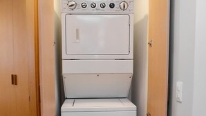 Uma lavanderia com máquinas de lavar e secar empilhadas.