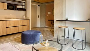 Eine moderne Küche mit Holzausstattung, einer eingebauten Mikrowelle und einer Theke mit Hockern.