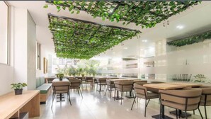 Un café moderne avec un long comptoir, de nombreuses tables et des chaises.