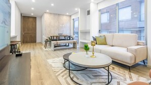 A modern living room with a sofa, coffee table, and dining area. - Designer 2BR in Usaqu n (Bogotá)