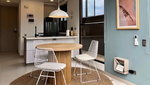 Une cuisine moderne avec un îlot central, des chaises blanches et un luminaire suspendu.