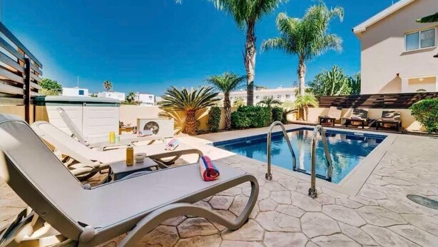 A rooftop pool area with lounge chairs and a palm tree. - Villa Marianna in Cape Greko with heated pool (Cape Greko)