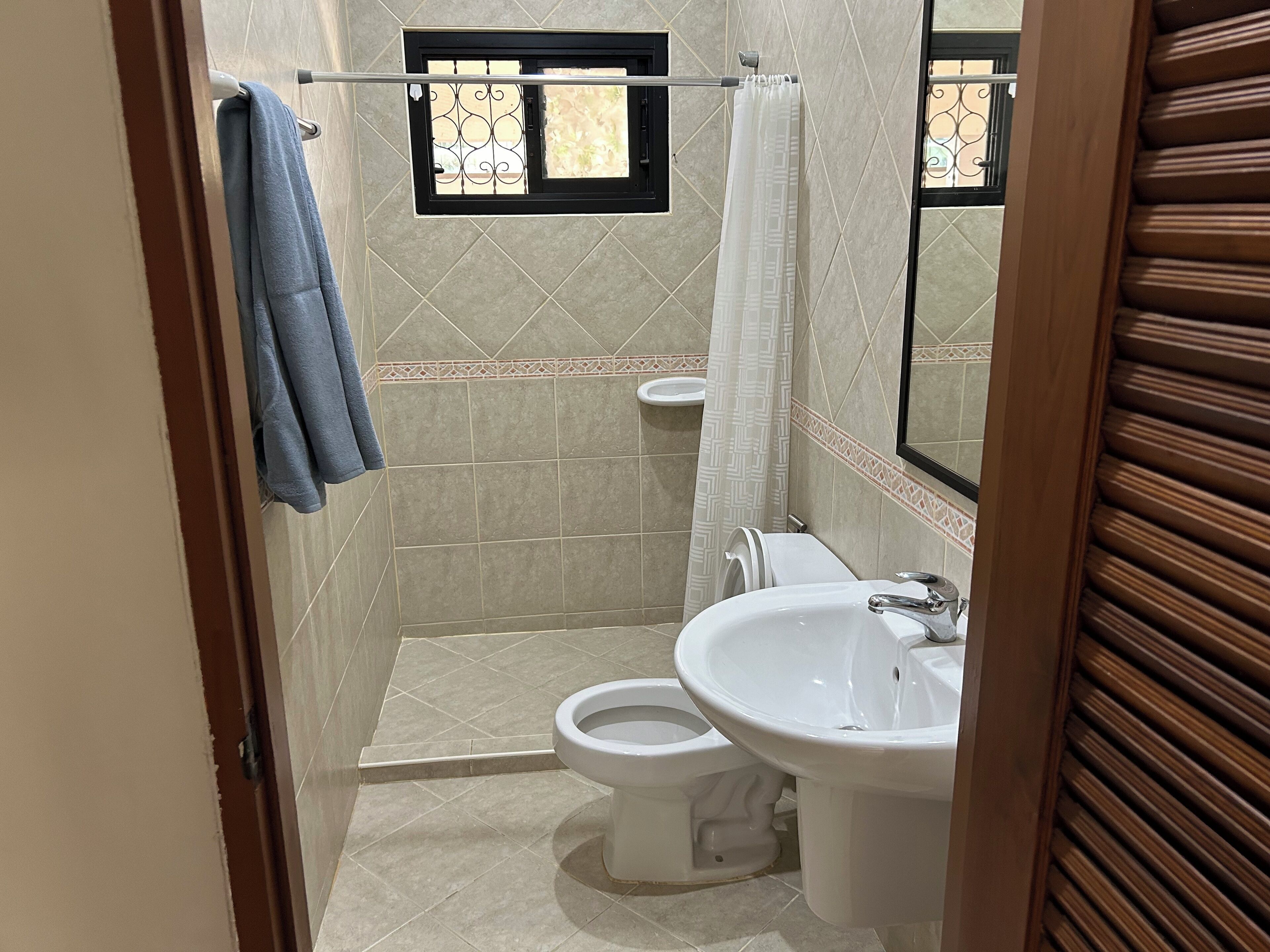 Un bagno con doccia, WC e lavandino.