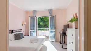 Un dormitorio con cama, escritorio, silla y ventana con cortinas.