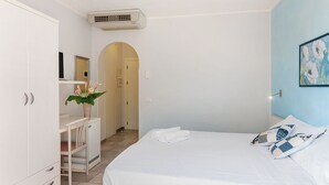 Un dormitorio con cama, escritorio y armario.