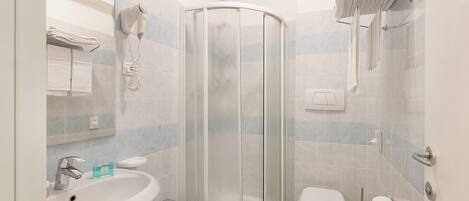 A modern bathroom with a shower enclosure, a sink, a bidet, and a toilet.