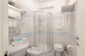 Une salle de bain moderne équipée d’une douche, d’un lavabo, d’un bidet et de toilettes.