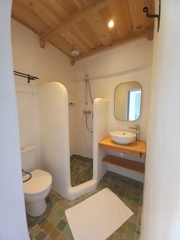 Un baño con inodoro, ducha y lavabo.
