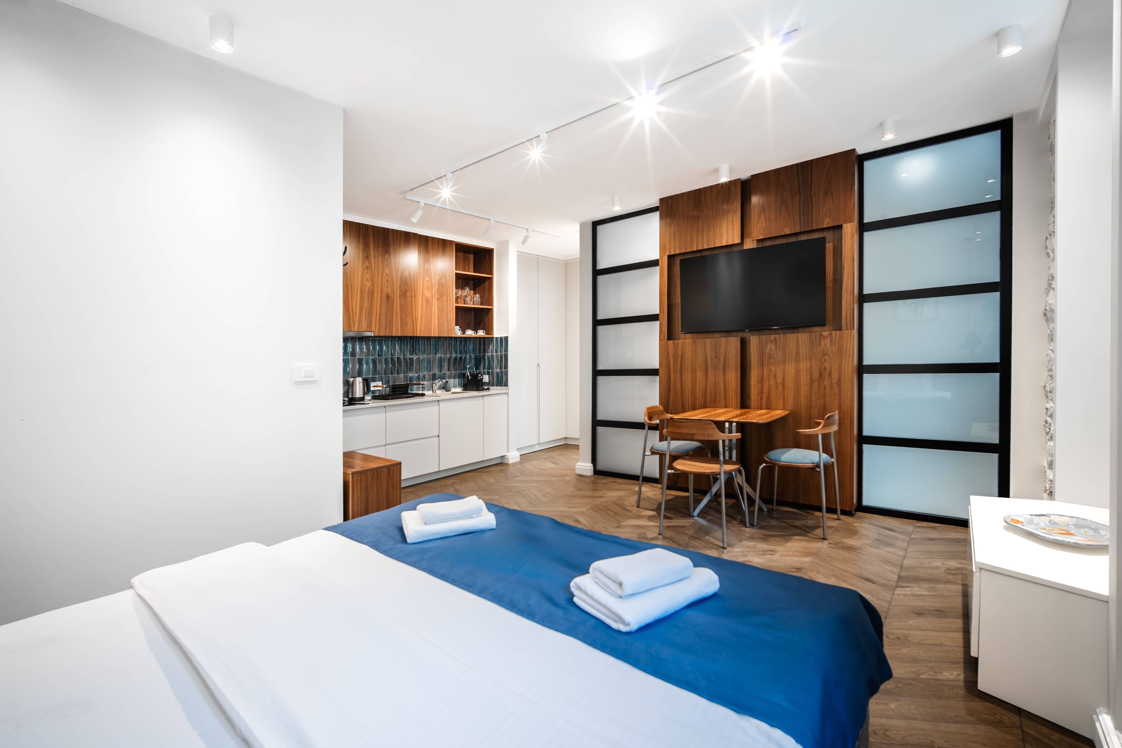 Une chambre d’hôtel moderne dotée d’un grand lit, d’un coin repas et d’une kitchenette.
