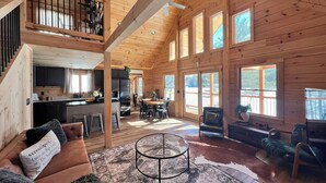 A spacious cabin with a loft bedroom, a kitchen, and a dining area.