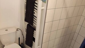 A bathroom with a toilet, a shower, and a towel rack. - Le Faubourg (Saint-Quentin)