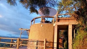 Estructura de bambú con una plataforma circular de observación y una entrada cubierta.