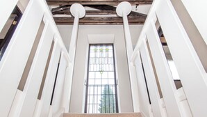 Un escalier avec des rampes blanches et un plafond en bois.