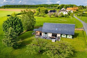 A house with a large garden, a paved driveway, and a solar panel on the roof. - Luxurious vacation home in the countryside in the Zittauer Gebirge Nature Park (Hainewalde)