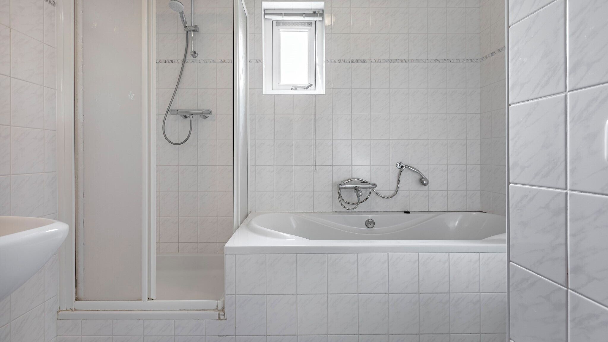 Ein modernes Badezimmer mit barrierefreier Dusche, Badewanne und Toilette.