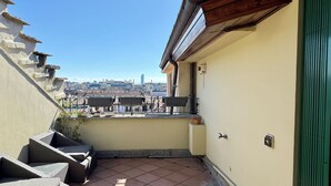 Ein Balkon mit Blick auf die Stadtlandschaft, darunter ein hoher Turm.