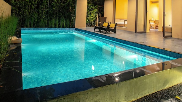 Una casa moderna con piscina, comedor y un gran ventanal que da a un patio.