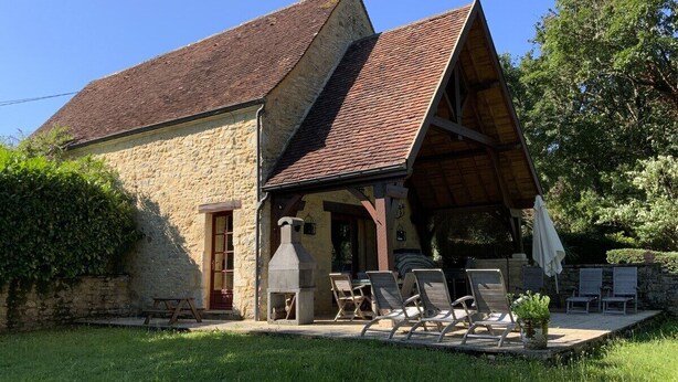 A stone building with a sloped roof, a barbecue area with chairs, and a small garden. - Beautiful house with heated pool. Quiet location, close to attractions. (Bouzic)