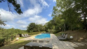 A backyard with a swimming pool, lounge chairs, and a dining table. - Beautiful house with heated pool. Quiet location, close to attractions. (Bouzic)
