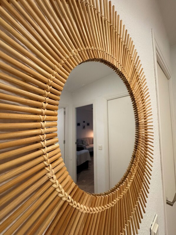 A circular mirror with a woven bamboo frame.