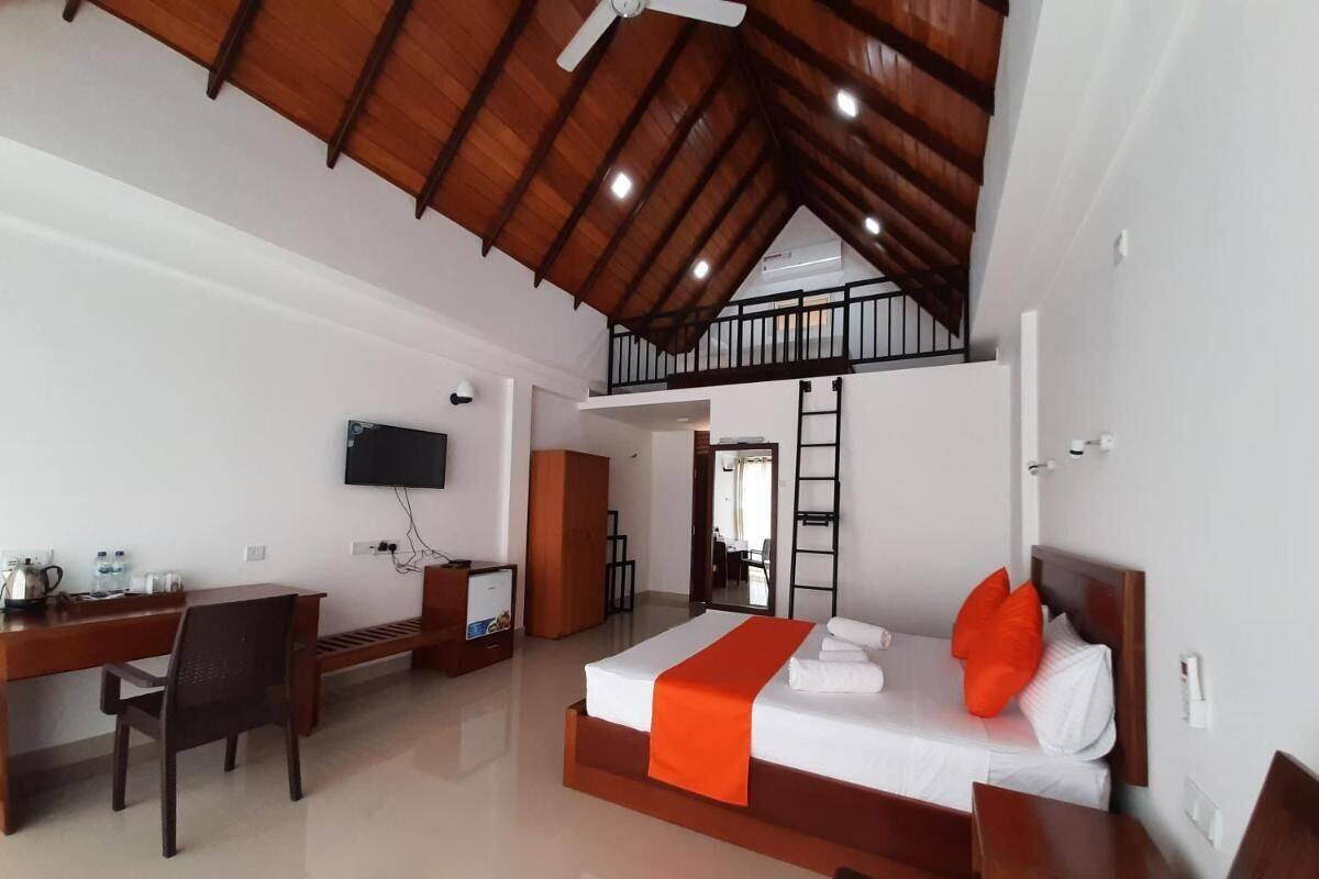 Habitación de hotel con un entrepiso para dormir, un escritorio y una televisión.