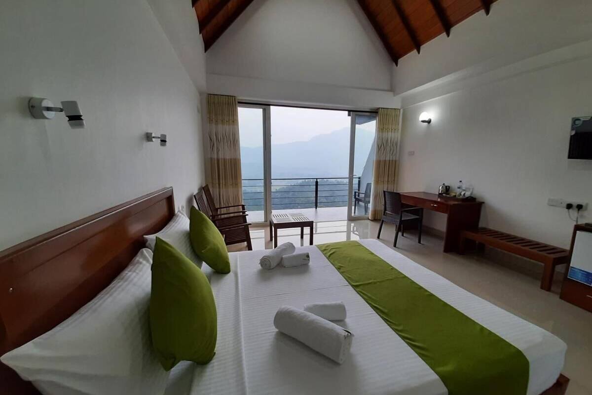 Habitación de hotel con una cama grande, un escritorio, una silla y vistas al mar.
