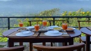 Une table dressée pour le petit-déjeuner, avec une vue sur les montagnes en arrière-plan.
