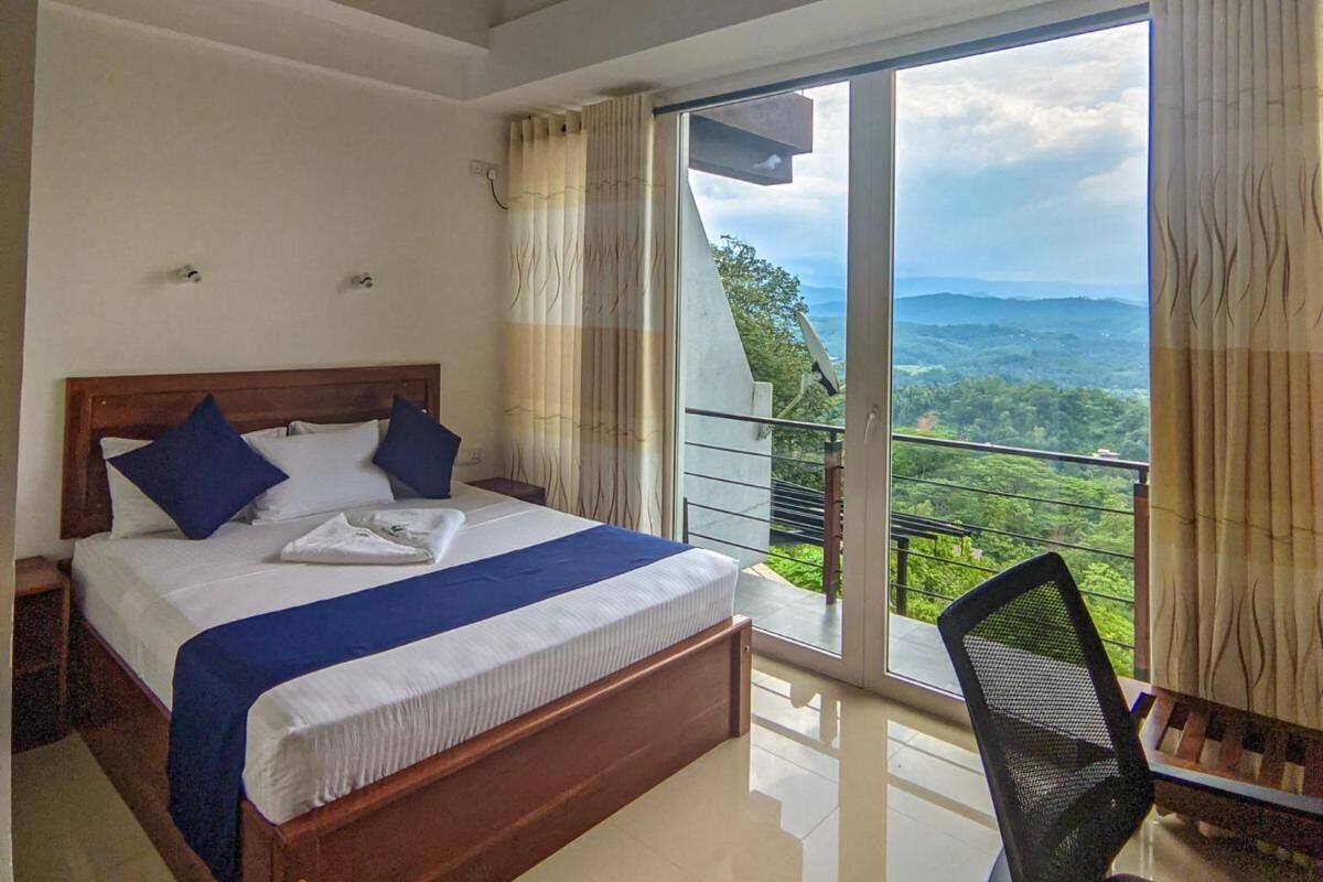Un dormitorio con una cama grande, una silla y un balcón con vistas al paisaje.