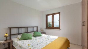 Une chambre à coucher avec un lit, deux lampes de chevet, une fenêtre et une armoire.