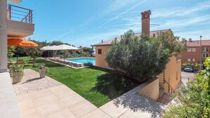 Une propriété résidentielle dotée d’une piscine, d’un patio avec mobilier d’extérieur et offrant une vue sur le quartier.