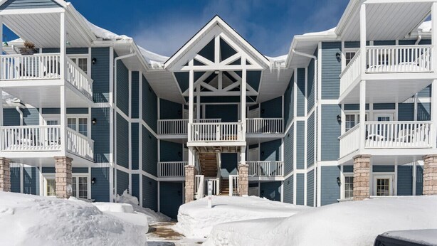 A multi-story building with balconies and a central entrance. - Peaceful Escape King Bed and Outdoor Activities (Shanty Bay)
